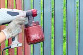hand painting fence with a spray gun