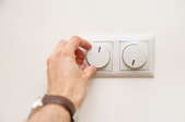 A man turns a dimmer switch.