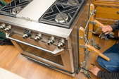 Worker Removes Appliance Dolly from New Kitchen Range