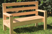 A completed wooden bench outside on the lawn.