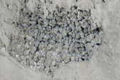 revealed stone honeycombing on rough concrete wall