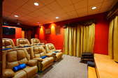 A home theater with large, leather chairs.