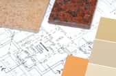 A collection of paint chips and granite samples over a home's blueprint. 