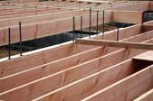 Wooden floor joists and rebar laid out for a wood foundation.