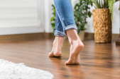 Bare feet walking on a hardwood floor. 