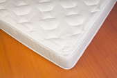 bare white mattress on laminate floor