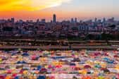 a flea market with colorful tents in a city at sunset
