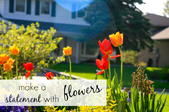 A flowerbed with a house in the background and the words 