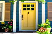 A yellow painted front door with windows.