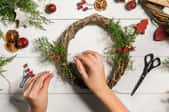 hands assembling holiday wreath