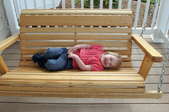 Child on a wooden porch swing