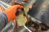 scooping leaves out of a gutter