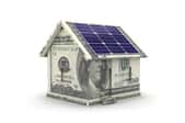 A house made of money with solar panels.