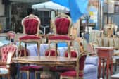 A grouping of antique and vintage furniture in a flea market. 