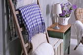 blanket ladder with blankets near wicker chair