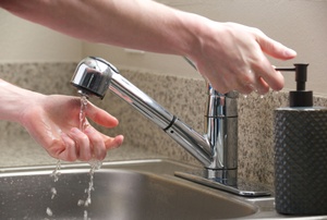 Someone washing hands in a sink.