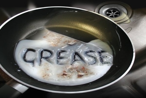 "Grease" written in a greasy frying pan.