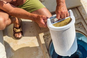 A man checking a pool filter. 