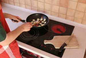 Someone cooking food on an induction cooktop. 