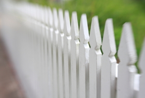 A traditional front yard fence painted white.