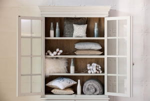 A white built-in cupboard with decor items inside. 