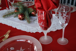 Several pieces of etched glassware in a holiday table setting.