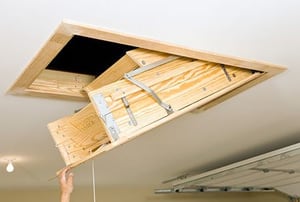Folding attic access ladder in a garage.