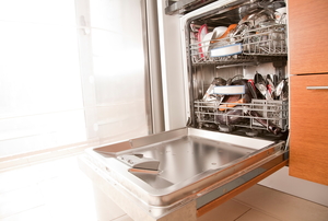 A dishwasher with a door hanging open in a bright room.