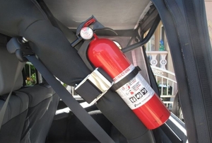A fire extinguisher secured in the trunk of a vehicle.