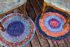 two colorful rugs sitting under chair on wood flooring