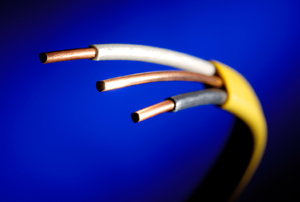 Exposed copper wires stick out of a cable shielding.