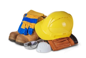 A pile of safety gear including a hard hat and gloves against a white background.