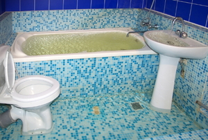 flooded bathroom with blue speckled tile