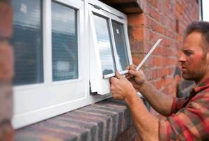 A carpenter fitting beading to a new window