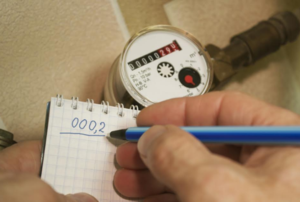 person recording numbers from a water meter onto a tablet