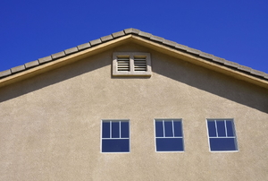 A home with a stucco exterior and a gable vent.