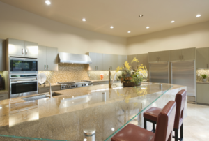 a large kitchen with huge island and rows of recessed lighting.