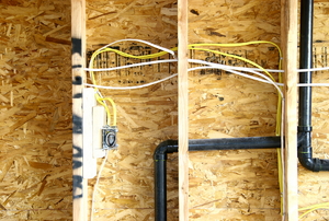 Framed wall with plumbing and electrical running through it