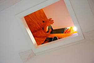 Looking up through the hatch at a worker in the attic.