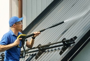 A man cleans a roof.