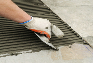 Laying tile on a floor.