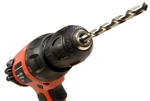 A close-up of the drill bit on a black and orange drill.