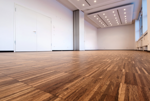 large room with bamboo flooring and white walls