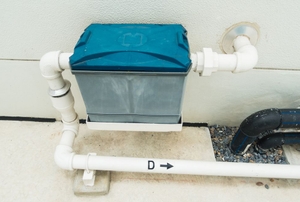 A grease trap installed on a pipe outside the home.