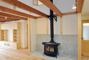 wood stove with chimney in room with rafters
