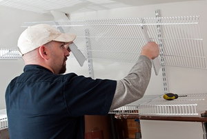 A man remodeling a space by adding shelving.