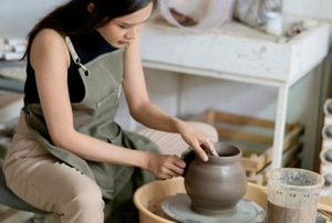 woman working on pottery in home studio