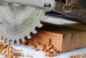 A circular saw cutting a wood plank.