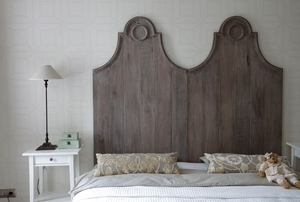 bed with tall, wooden headboard