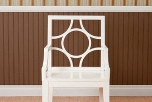 a chair in front of a wall with molding and line patterns